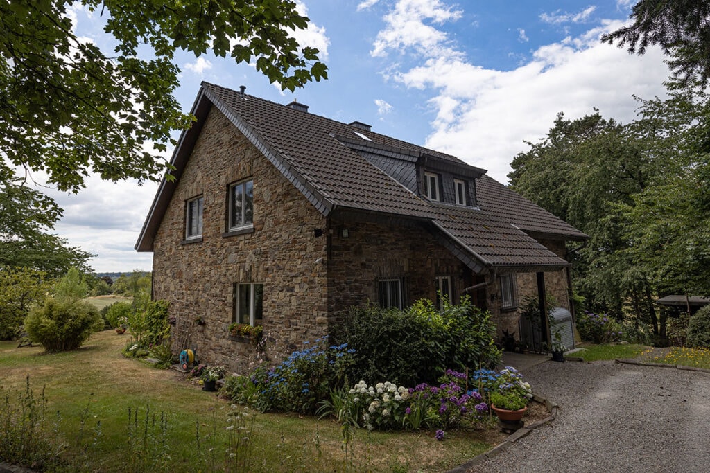 Steinhaus mit Garten und Bäumen im Grünen
